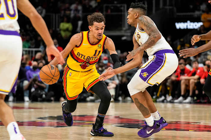 Hawks guard Trae Young dribbles past Lakers guard Malik Monk.